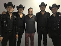 a group of men in black hats posing for a photo